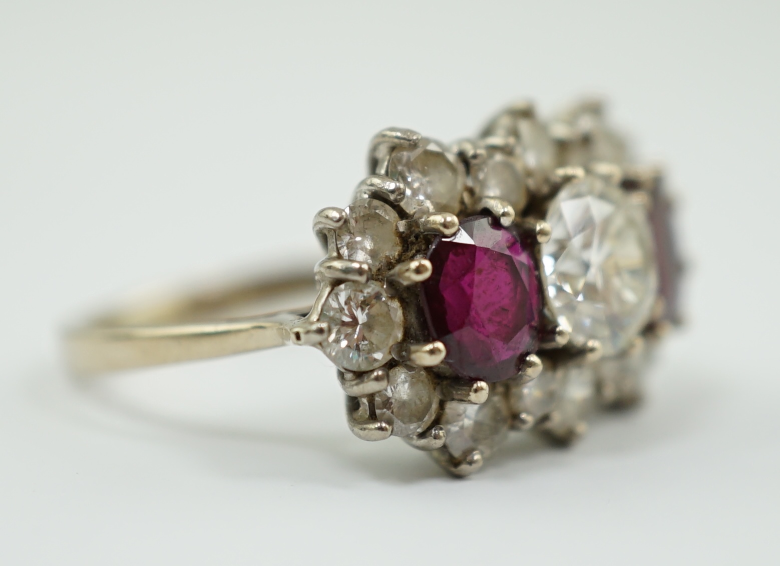 A 1970's 18ct white gold, ruby and diamond set triple cluster dress ring